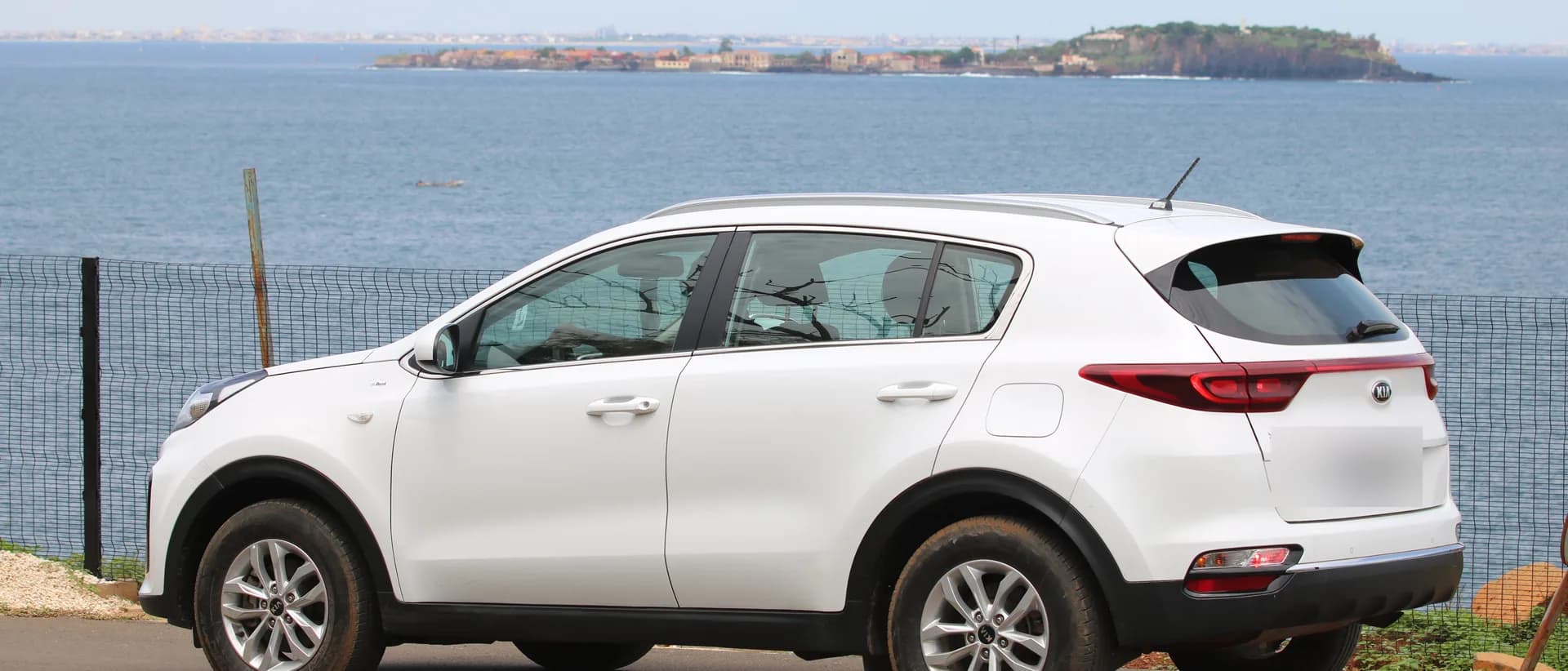 Un véhicule de la flotte Dakar VTC sur la corniche de Dakar, l'île de Gorée à l'horizon